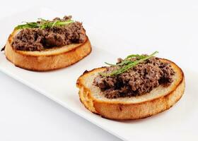 delicious italian bruschetta with truffle pate on white plate photo