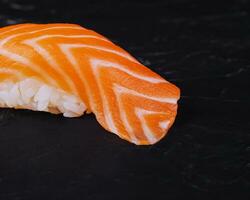 Salmon nigiri sushi on black stone photo