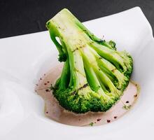 Broccoli steak with walnut sauce on plate photo