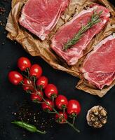 Raw strip loin steaks on baking paper photo