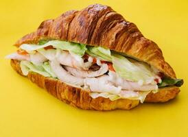 croissant sandwich ham on yellow background photo