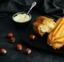 Eclairs with cream on stone board photo