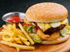 Juicy burger with onion rings and french fries photo