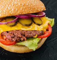 Fresh tasty burger on black background photo