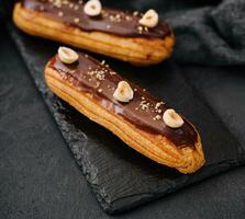 french eclairs with chocolate and hazelnuts photo