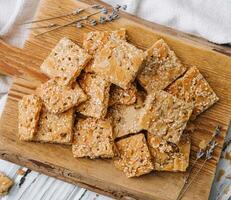 Multigrain cereal crunchy squares bars with pumpkin seeds on wooden background photo