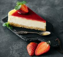 Strawberry cheesecake slice close up on a dark photo