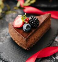 Delicious chocolate cake decorated with fresh berries on stone table photo