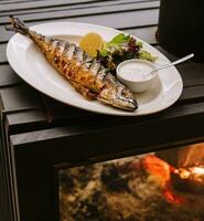 Fried fish with fish sauce beautifully placed on a plate photo