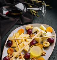 Cheese platter with organic cheeses, fruits, nuts and wine photo