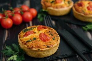 Cheddar cheese and spring onion omelette tarts served on wooden board photo