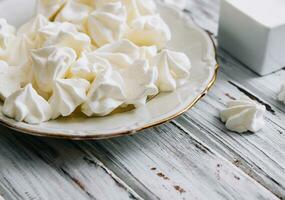 Meringue cookies in in a plate on wood photo