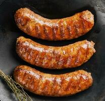 fried sausages on black pan from above photo