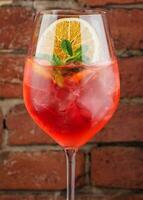 Fresh cold strawberry alcoholic drink with orange, ice and mint photo