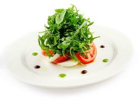 Green salad with arugula, tomato and feta cheese photo