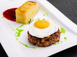 fried vegetable tartare with egg on plate photo