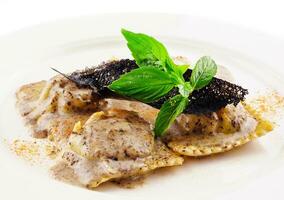 Ravioli in creamy truffle sauce on plate photo