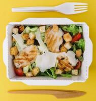 Caesar salad packed on craft box for take away photo