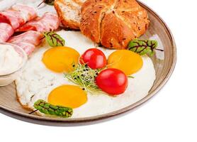 Plate of breakfast with fried eggs, bacon and toasts isolated on white photo