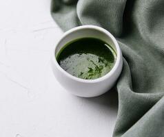 Bowl with delicious basil pesto sauce photo