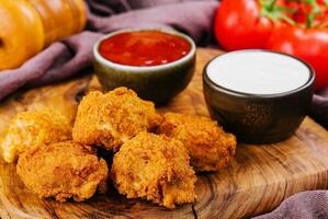 Tasty traditional chicken nuggets closeup and vegetables photo