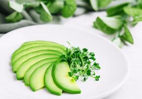 Sliced avocado on white plate photo