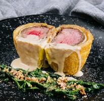 Pork tenderloin en croute on black plate photo