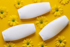 Bottle of Mockup cosmetic products with chamomile flowers photo