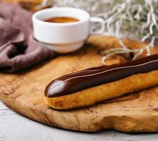 Eclairs with chocolate and a coffee cup photo