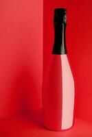 Red bottle of champagne on red background photo