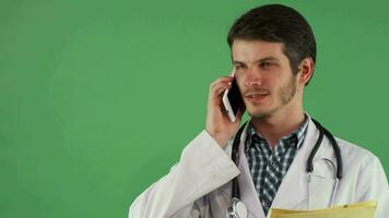 skäggig manlig läkare talande på de telefon ser fokuserade video
