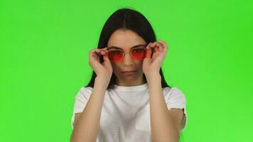 Close up studio shot of a gorgeous brunette wearing pink eyeglasses video