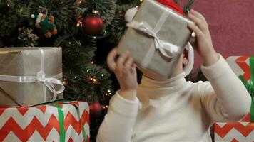 Little boy shakes the christmas gift box video