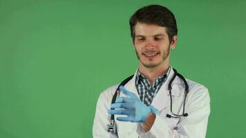 Handsome bearded male doctor putting on medical rubber gloves video