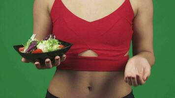 Cropped shot of a woman choosing between salad and vitamins in pills video