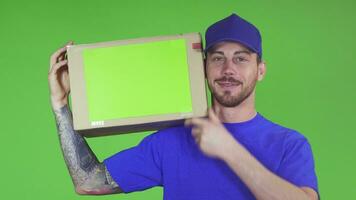 Happy deliveryman smiling putting cardboard box with copyspace on his shoulder video