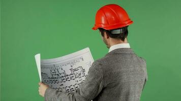 Handsome bearded engineer smiling to the camera while examining blueprints video