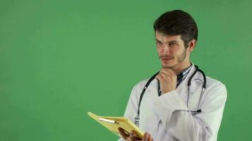 Handsome male doctor having an idea while examining documents video