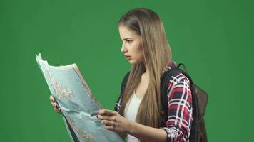 Beautiful young female tourist looking at the map with a confused expression video