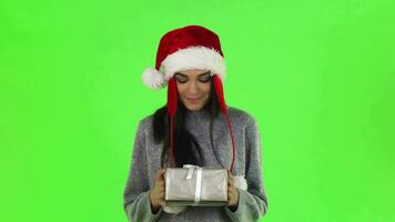Beautiful Santa girl smiling holding out Christmas gift to the camera video