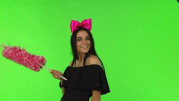 Young beautiful woman wearing pink bow posing with a duster video