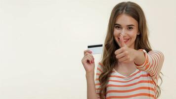 Attractive girl showing thumbs-up with credit card video