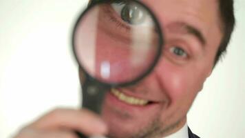 Male looking through magnifying glass video