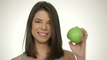 Girl holds green apple, isolated over white background video