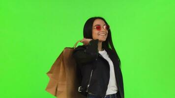 feliz jovem mulher posando com dela compras bolsas em chromakey video