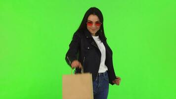 contento hermosa elegante mujer participación fuera compras bolso a el cámara video