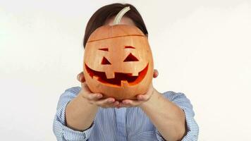 Woman hiding her face behind carved Halloween pumpkin video