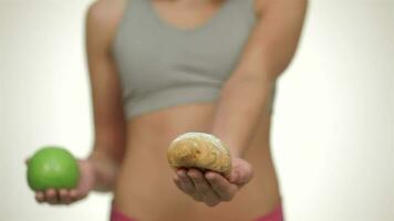 The girl offers a choice between a sweet treat or a healthy fruit video