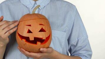 Woman petting Halloween pumpkin isolated on white video