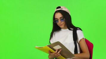 glücklich jung weiblich Schüler posieren mit ihr Bücher und Rucksack video